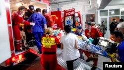 Radnici hitne pomoći iznose jednog od povređenih u noćnom klubu "Kolektiv" ispred bolnice u Bukureštu