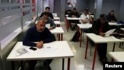 Osama Abdul Mohsen (L), a Syrian refugee, attends a Spanish lessons at a YMCA social center in Getafe, outside Madrid, Spain, April 21, 2016. 