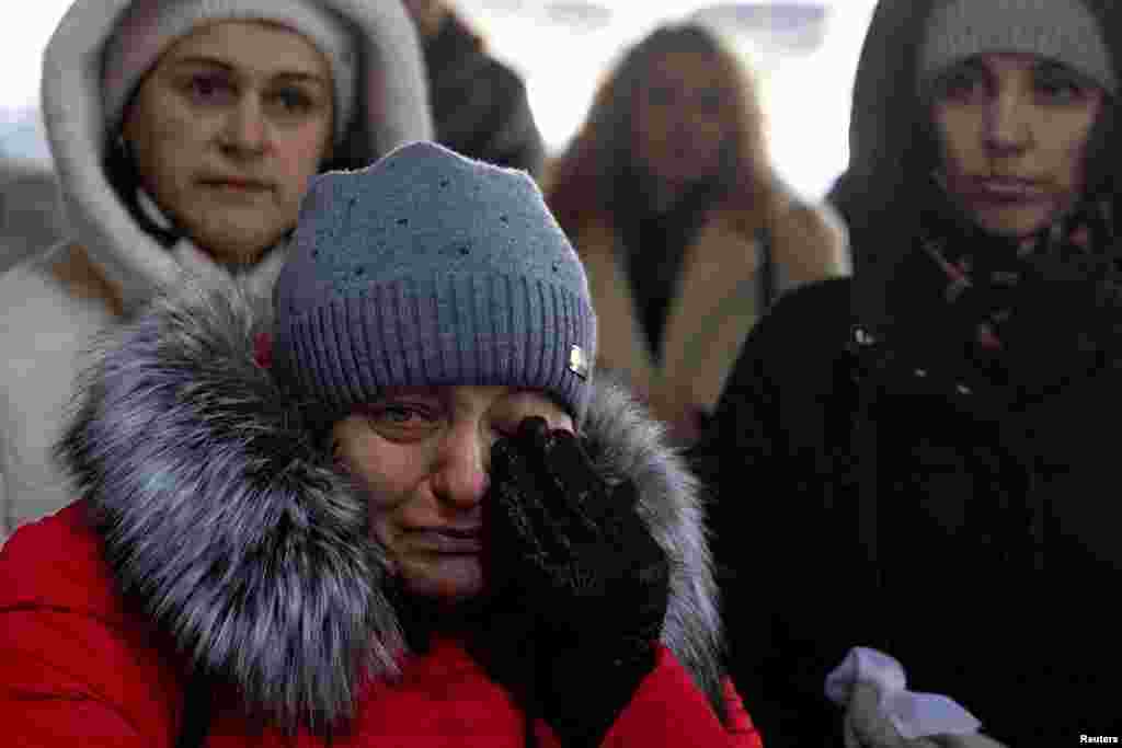 People attend a memorial event marking the 3rd anniversary of Russia&#39;s invasion of Ukraine at Romanivska Bridge that was destroyed at the beginning of the war in Irpin outside in Kyiv, Ukraine.