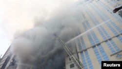 Petugas pemadam kebakaran berupaya memadamkan api yang menghanguskan bangunan berlantai 19 di kawasan komersial Banani di Dhaka, Bangladesh, Kamis 28 Maret 2019.