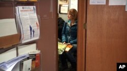 In this Jan. 16, 2014 photo, Debbie Jurcak, an unemployed mother of three, waits for her turn to select groceries at a food pantry in Woodridge, Illinois. 