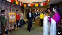 Ibu negara AMerika, Michelle Obama bersama dua putrinya, Sasha dan Malia dan ibunya Marian Robinson, disambut murid-murid dari Tibet setibanya di restoran Tibet di Chengdu di provinsi Sichuan, China (26/3).