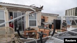 FILE - Homeowner Joe Lovece surveys the damage to the kitchen at the back of his oceanfront home after the eye of Hurricane Matthew passed Ormond Beach, Fla., Oct. 7, 2016. 