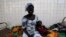 FILE - A woman sits beside her sick child in the pediatric ward at the general hospital in Man, western Ivory Coast, July 4, 2013. 