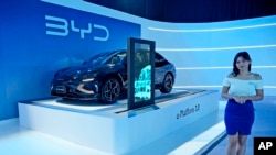 FILE - A model stands near a BYD Seal electric car displayed during its launch event in Jakarta, Indonesia, on Jan. 18, 2024. (AP Photo/Achmad Ibrahim, File)
