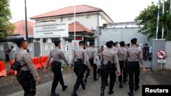 Polisi berjalan di dekat gerbang ke pelabuhan feri untuk pulau penjara Nusa Kambangan, menjelang eksekusi 14 narapidana narkoba, termasuk setidaknya empat orang asing, di Cilacap, Jawa Tengah, Indonesia 28 Juli 2016. (REUTERS / Darren Whitesid).