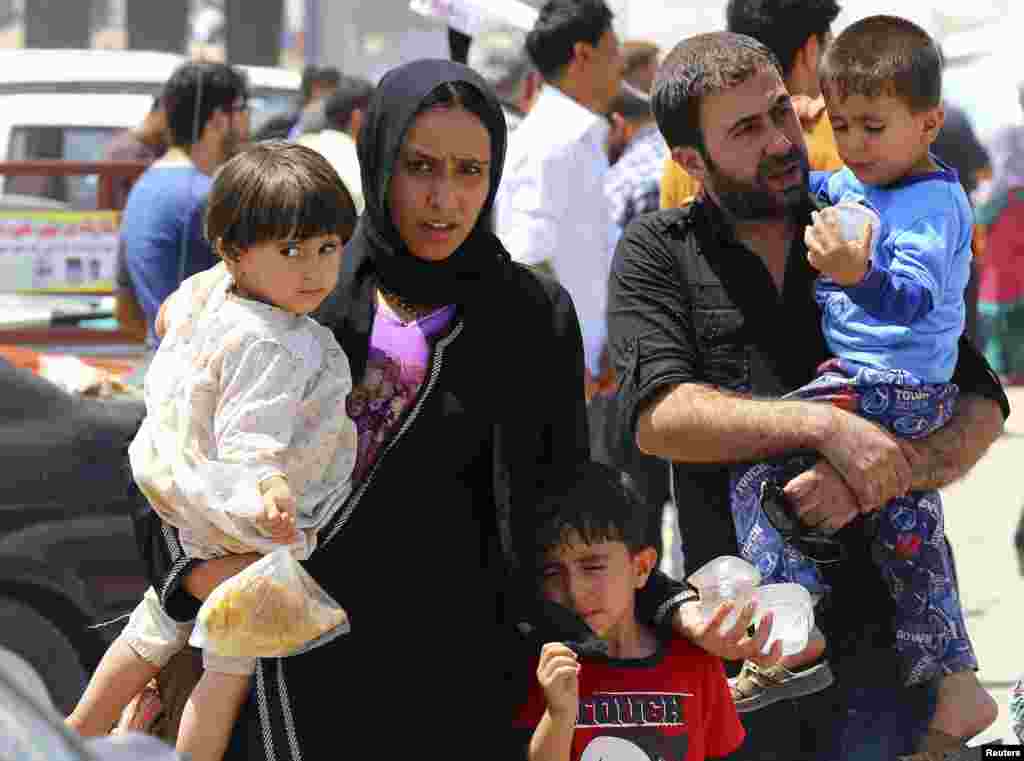 A family fleeing the violence in the Iraqi city of Mosul waits at a checkpoint in Kurdistan region.&nbsp; Sunni Muslim insurgents seized control of most of Mosul, the country&#39;s second largest city.