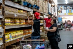 FILE - People bargain  groceries astatine  a supermarket that accepts 'chachos' currency successful  La Rioja, Argentina, Sept. 23, 2024.