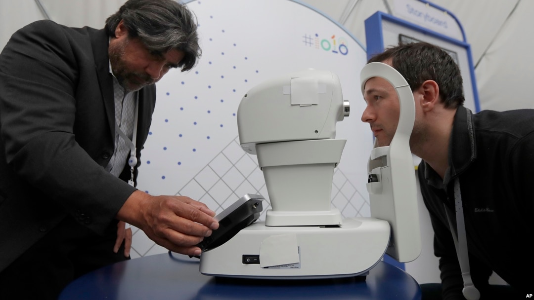 Jorge Cuadros, kiri, mendemonstrasikan robot kamera retina kepada seorang wartawan pada konferensi I/O Google di Mountain View, California, Selasa, 8 Mei 2018 (foto: AP Photo/Jeff Chiu)
