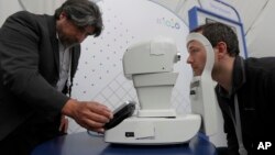 Jorge Cuadros, kiri, mendemonstrasikan robot kamera retina kepada seorang wartawan pada konferensi I/O Google di Mountain View, California, Selasa, 8 Mei 2018 (foto: AP Photo/Jeff Chiu)