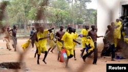 FILE - Prisoners runs towards their ward after their prison riot was quelled at the Lira Central Prison in Northern Uganda, Feb. 13, 2013. 