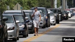 Fila de vehículos a la espera de recibir bolsas de arena en Kissimmee, Florida, en preparación a la llegada del huracán Irma.