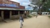 FILE - A man passes the local cafe as a woman and her child cross the main street in the village of Chimanimani some 420 km southeast of Harare, May 18, 2000.