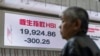 A pedestrian passes by an electronic screen displaying the Hang Seng Index on the first trading day of the Year of Snake in Hong Kong, Feb. 3, 2025. 