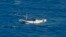 In this July 4, 2012 file photo released by the Indonesian National Search and Rescue Agency, a wooden boat which is believed to have up to 180 asylum seekers on board floats on the waters off Christmas Island, Australia.