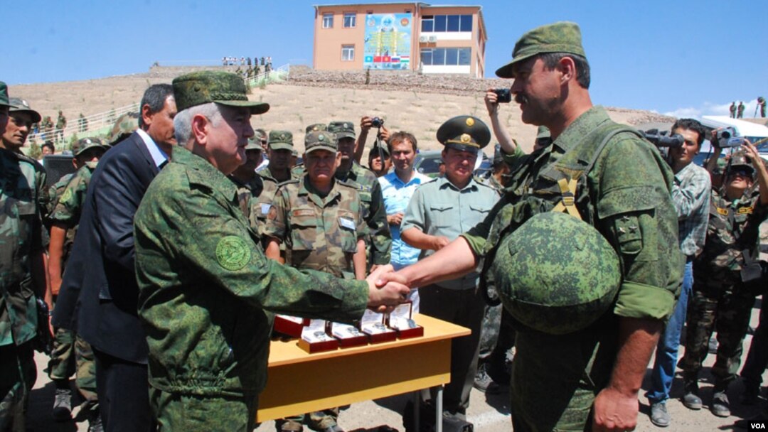 Tojikiston mudofaa vaziri mashqlarni a'lo bajargan rus ofitserini tabriklamoqda.