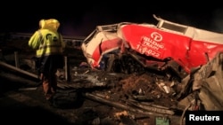 A man walks at the site of a crash, where two trains collided, near the city of Larissa, Greece, March 1, 2023.