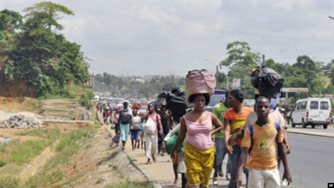 Residents of the popular district of Abobo, a suburb of Abidjan, flee fighting on February 25, 2011
