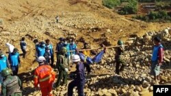  2015年11月22日在缅甸克钦邦玉石矿山体滑坡区士兵在协助搬运死难矿工的尸体。
