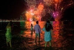 People celebrate as they watch the traditional New Year's fireworks at Copacabana Beach in Rio de Janeiro, Dec. 31, 2019.