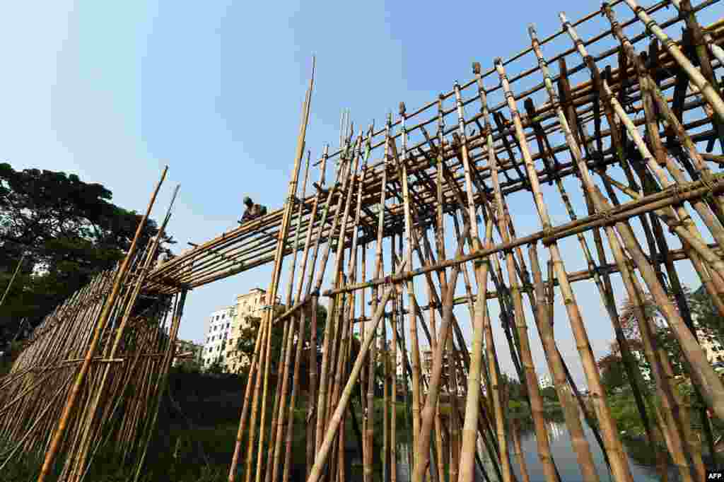 방글라데시 다카에서 한 수리공이 대나무 다리를 고치고 있다. 