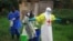 FILE - In this photo taken Sept 9, 2018, a health worker sprays disinfectant on his colleague after working at an Ebola treatment center in Beni, DRC.