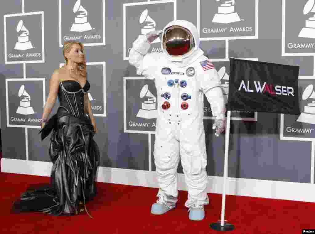 Singer Olga Levit looks on as DJ Al Walser, who is nominated for best dance recording, salutes photographers as they arrive at the 55th annual Grammy Awards in Los Angeles, California February 10, 2013. REUTERS/Mario Anzuoni (UNITED STATES - Tags: ENTE