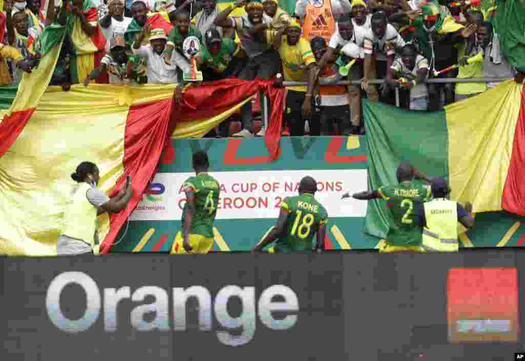 Mali's Ibrahima Kone, centre, celebrates with teammates and fans after scoring his team's first goal, during the soccer match between Gambia and Mali, Cameroon, Jan. 16, 2022.