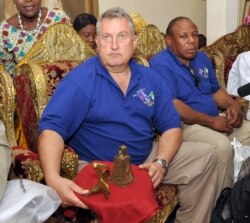 FILE - Steve Dunstone, of the Richard Lander Society, holds 2 bronze artefacts taken away during the British invasion of Benin in 1897, and returned to Benin by a British pensioner, during a ceremony in Benin City, Nigeria, June 20, 2014.