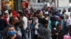 Grupos de personas, la mayoría protegidos con máscaras, llenan una popular calle de tiendas en Sao Paulo, Brasil, el 15 de julio de 2020.