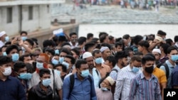 People crowd a ferry terminal to leave the city ahead of a lockdown set to start on July 1, at the Shimulia ferry terminal in Munshiganj, on the outskirts of Dhaka, Bangladesh, June 30, 2021. 