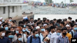 People crowd a ferry terminal to leave the city ahead of a lockdown set to start on July 1, at the Shimulia ferry terminal in Munshiganj, on the outskirts of Dhaka, Bangladesh, June 30, 2021. 