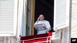 Pope Francis waves to faithful from his studio window overlooking St. Peter's Square at the Vatican, as he leaves at the end of the Angelus prayer, July 5, 2020.