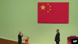 Macao's new leader, Sam Hou Fai, left, is sworn in by China's President Xi Jinping during an inauguration ceremony as part of marking the 25th anniversary of Macao's handover from Portugal to China, in Macao, Dec. 20, 2024. 