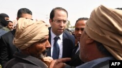 Le Premier ministre tunisien Youssef Chahed s'entretient avec quelques personnes à son arrivée dans la ville de Tataouine, le 27 avril 2017.