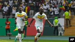 Senegal's Pape Gueye, right, celebrates after scoring the opening goal during the African Cup of Nations Group C soccer match against Gambia at the Charles Konan Banny stadium in Yamoussoukro, Ivory Coast, Jan. 15, 2024.