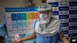 A doctor demonstrates the use of high-flow oxygen equipment used to treat patients with moderate symptoms from COVID-19 as he gives a media tour of the public Almenara Hospital in Lima, Peru, Jan. 22, 2021.