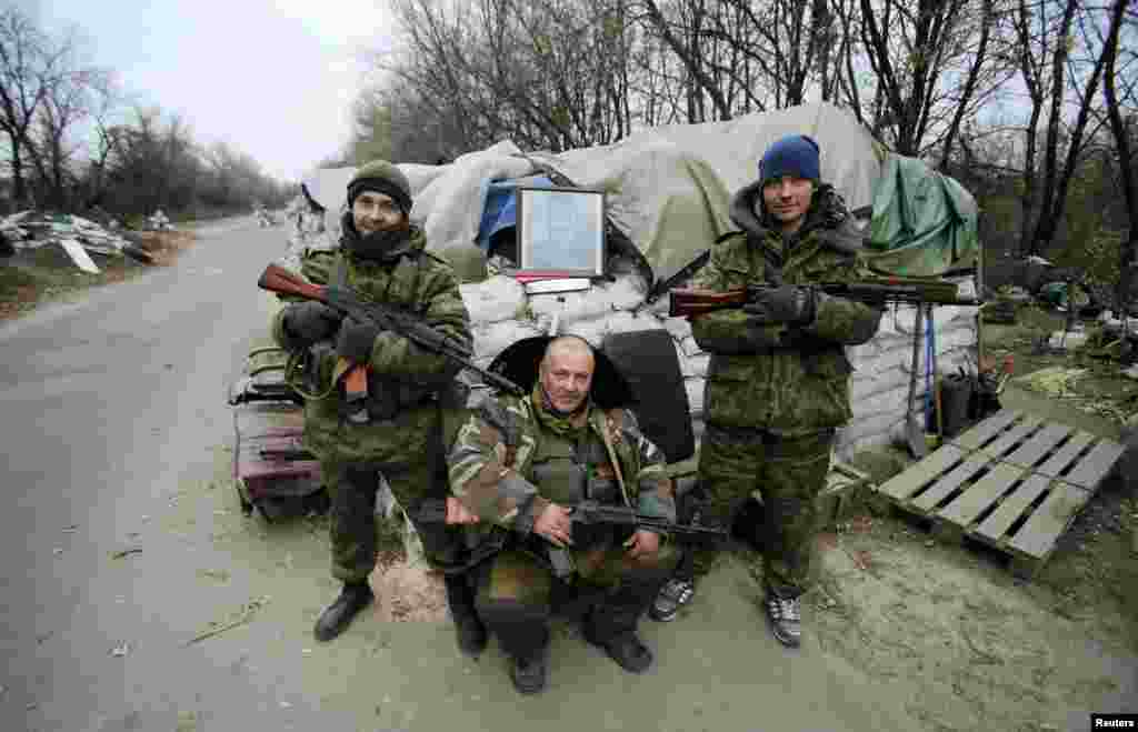 Pro-Russian separatists pose with a picture of Josef Stalin at checkpoint in the Spartak area near the Sergey Prokofiev International Airport in Donetsk, Nov. 18, 2014.