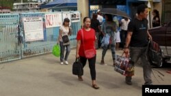 Stranded passengers leave the port after learning that ferry services were stopped in preparation for an approaching storm in Marinduque island, central Philippines, April 4, 2015.