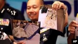 Seorang polisi Malaysia dari unit Penyelidikan Kejahatan Komersial memperlihatkan gambar perhiasan-perhiasan yang disita dari kediaman mantan Perdana Menteri Malaysia Najib Razak, dalam konferensi pers di Kuala Lumpur, Malaysia, Rabu, 27 Juni 2018.