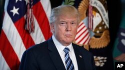 President Donald Trump listens as Treasury Secretary Steve Mnuchin speaks at the Treasury Department in Washington, April 21, 2017. 