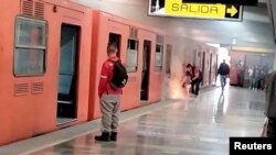 Un empleado intenta apagar un fuego bajo uno de los vagones del metro, en una estación de Ciudad de México, compartida por la usuaria de Twitter @isa_uriel, el 11 de enero de 2023.