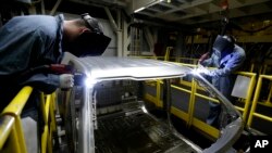 FILE - Workers weld body panels on Ford pickup trucks at the company's Kansas City Assembly Plant in Claycomo, Mo. U.S. worker productivity increased at a 3.1 percent rate in the third quarter, the Labor Department reported Thursday.