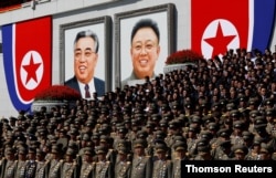 FILE - Senior military officials watch a parade as portraits of the late North Korean leaders Kim Il Sung and Kim Jong Il are seen at the main Kim Il Sung square in Pyongyang.