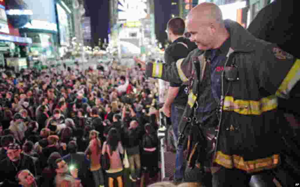 A firefighter waves to the crowd as people celebrate after Al Qaeda leader Osama bin Laden was killed in Pakistan, during a spontaneous celebration in New York's Times Square, May 2, 2011