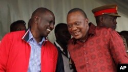 Kenyan President Uhuru Kenyatta (right) talks with Vice President William Ruto during the unveiling of a cargo train at the Mombasa, Kenya, port containers depot, May 30, 2017.