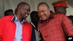 Kenyan President Uhuru Kenyatta (right) talks with Vice President William Ruto during the unveiling of a cargo train at the Mombasa, Kenya, port containers depot, May 30, 2017.