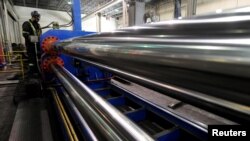 FILE - Workers are seen at at Bri-Steel Manufacturing, a manufacturer and distributer of seamless steel pipes, in Edmonton, Alberta, Canada, June 21, 2018.