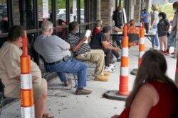 FILE - In this July 15, 2020, photo, job seekers exercise social distancing as they wait to be called into the Heartland Workforce Solutions office in Omaha, Neb.