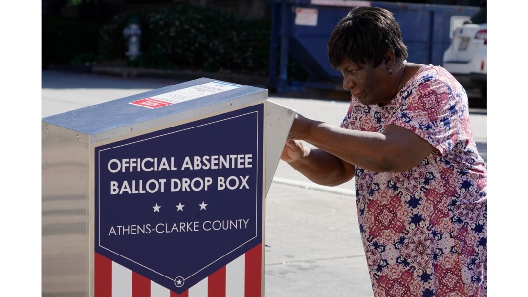 A voter drops off her ballot during early voting in Athens, Ga., Oct. 19, 2020. (AP)